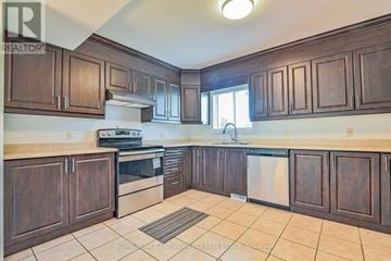 Amaranth apartment for rent - A kitchen with brown cabinets and a white stove top oven.