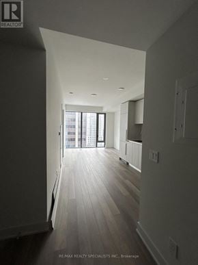 Toronto (Annex) condo for rent - A long hallway with wood floors and white walls.
