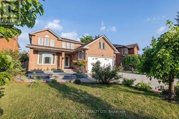 Mississauga (East Credit) apartment for rent - A large, two-story house with a brick exterior and a white trim is surrounded by a well-kept lawn and trees.
