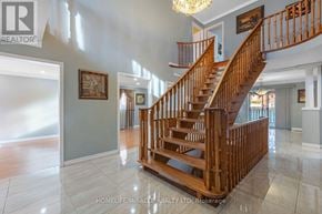 Mississauga (East Credit) apartment for rent - A wooden staircase in a spacious home with a chandelier hanging from the ceiling.