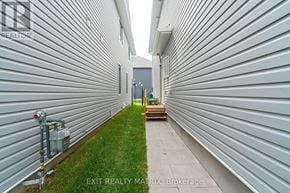 Ottawa apartment for rent - A narrow alley with a green lawn and a building on the left.