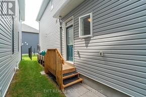 Ottawa apartment for rent - A house with a grey siding and a wooden deck.