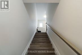 Ottawa apartment for rent - A staircase leading to a white door with a window on the side.