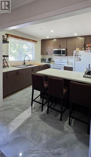 Mississauga (Streetsville) townhouse for rent - A kitchen with brown chairs and a white fridge.