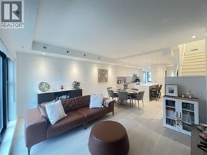 Vancouver townhouse for rent - A living room with a brown couch and a dining table.