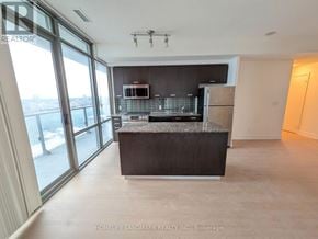 Toronto (Bay Street Corridor) condo for rent - A spacious kitchen with a granite countertop and stainless steel appliances.