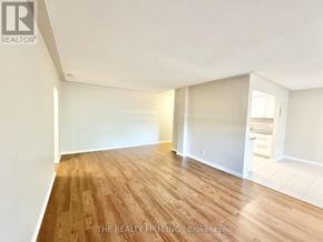 London South (South F) condo for rent - A room with wooden flooring and white walls, with a logo for "The Realty Firm Inc. Brokerage" on the bottom.