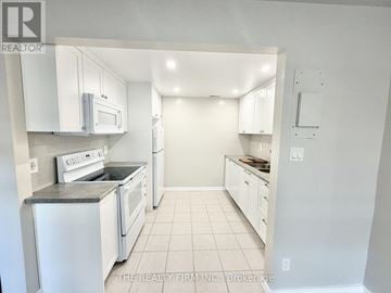London South (South F) condo for rent - A white kitchen with a microwave and oven built into the cabinetry.