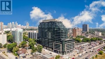 Mississauga (Cooksville) condo for rent - A large building under construction is the focal point of a cityscape.