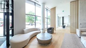 Mississauga (Cooksville) condo for rent - A modern living room with a large window and a curved sofa.
