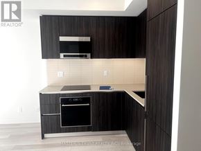 Toronto (Annex) condo for rent - A modern kitchen with dark wood cabinets and a built-in oven.
