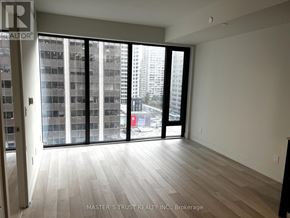 Toronto (Annex) condo for rent - A room with a large window overlooking a cityscape.