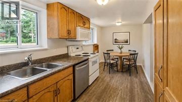 Guelph apartment for rent - A kitchen with wooden cabinets and a dining table.