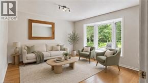 Guelph apartment for rent - A living room with a white couch, a coffee table, and a mirror on the wall.