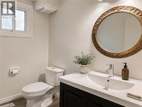Guelph apartment for rent - A bathroom with a toilet, sink, and mirror.