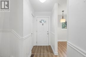 Hamilton (Gilkson) townhouse for rent - A hallway with a white door and a light hanging from the ceiling.