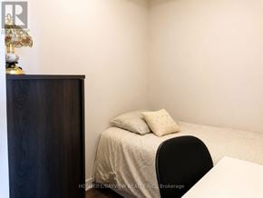 Richmond Hill (Langstaff) condo for rent - A bedroom with a bed, chair, and a cabinet.