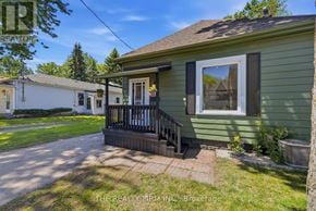 London East (East M) apartment for rent - A green house with a porch and a white house in the background.