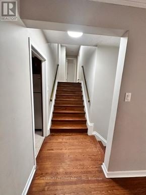 Toronto (Highland Creek) apartment for rent - A long hallway with a staircase and white walls.
