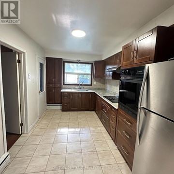Toronto (Highland Creek) apartment for rent - A kitchen with brown cabinets and a stainless steel refrigerator.