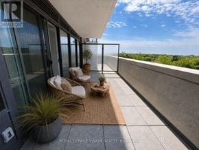 Toronto (Humber Heights) condo for rent - A balcony with a chair and a table with a potted plant on it.