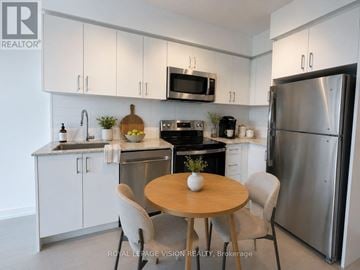 Toronto (Humber Heights) condo for rent - A kitchen with a table and chairs in front of a refrigerator.