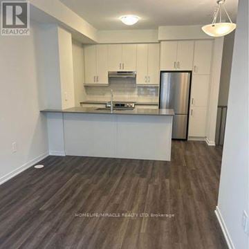 Vaughan (Vaughan Corporate Centre) townhouse for rent - A kitchen with white cabinets and a wooden floor.