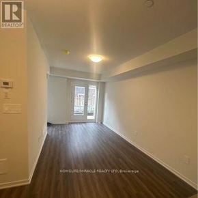 Vaughan (Vaughan Corporate Centre) townhouse for rent - A room with wooden flooring and a window with a view of buildings outside.