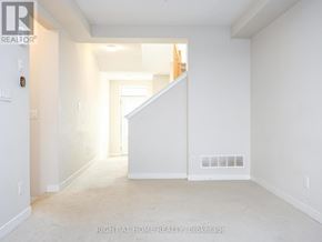 Ottawa townhouse for rent - A white room with a staircase leading to another room.