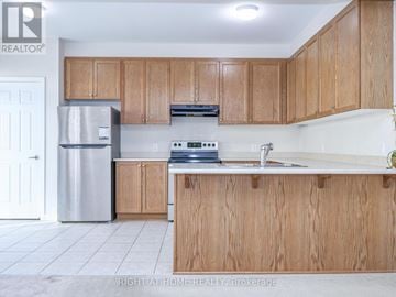 Ottawa townhouse for rent - A kitchen with wooden cabinets and a stainless steel refrigerator.