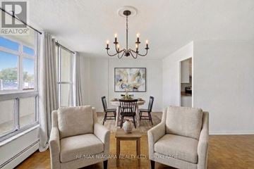 St. Catharines (Glendale/Glenridge) condo for rent - A living room with a dining table and chairs.