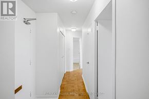 St. Catharines (Glendale/Glenridge) condo for rent - A long hallway with white walls and a wooden floor.