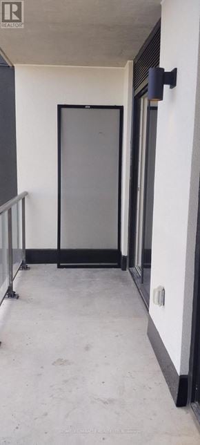 Brantford condo for rent - A black door is in a white hallway.
