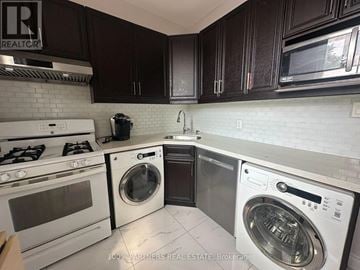 Toronto (Trinity-Bellwoods) apartment for rent - A clean, modern kitchen with dark brown cabinets and white appliances.