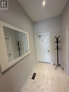 Toronto (Trinity-Bellwoods) apartment for rent - A hallway with a mirror, a door, and a coat stand.