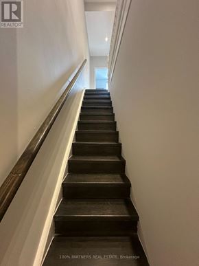Toronto (Trinity-Bellwoods) apartment for rent - A staircase with a metal handrail and wooden steps.
