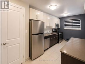 St. Catharines (Downtown) multi-family for rent - A kitchen with a refrigerator, microwave, and oven.