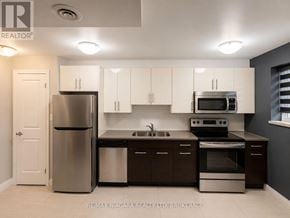 St. Catharines (Downtown) multi-family for rent - A kitchen with white cabinets and stainless steel appliances.