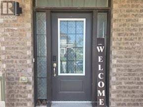 Oshawa (Eastdale) apartment for rent - A black door with a glass window and a welcome sign on the wall.