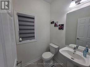 Oshawa (Eastdale) apartment for rent - A bathroom with a toilet, sink, and window.