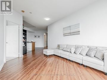 Mississauga (Hurontario) condo for rent - A living room with a white couch and wooden floors.