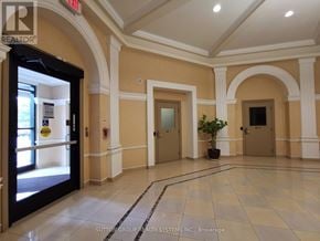 Mississauga (Hurontario) condo for rent - A hallway with a plant in the middle and doors on both sides.