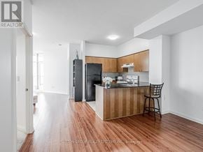 Mississauga (Hurontario) condo for rent - A kitchen with a refrigerator, sink, and bar stool.