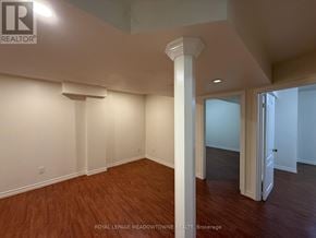 Brampton (Northwest Brampton) apartment for rent - A room with wooden floors and white walls, with a column in the middle.