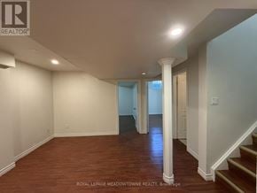 Brampton (Northwest Brampton) apartment for rent - A spacious room with wooden floors and white walls.