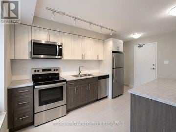 St. Catharines (Downtown) multi-family for rent - A kitchen with a stove, oven, microwave, and refrigerator.