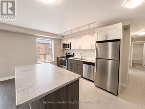 St. Catharines (Downtown) multi-family for rent - A kitchen with stainless steel appliances and a large island.