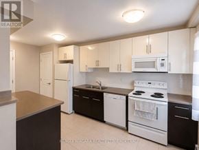 St. Catharines (Downtown) multi-family for rent - A kitchen with white appliances and brown countertops.