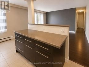 St. Catharines (Downtown) multi-family for rent - A kitchen with a countertop and cabinets.