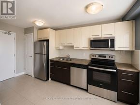St. Catharines (Downtown) multi-family for rent - A kitchen with white cabinets and stainless steel appliances.